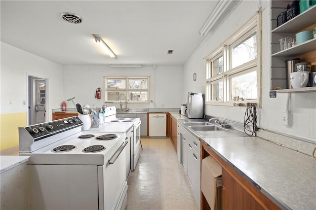 kitchen with stainless steel counters, sink, and white appliances