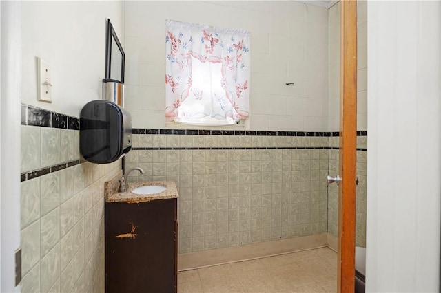 bathroom with tile patterned flooring, vanity, and tile walls