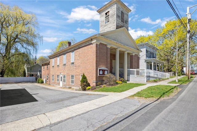 18 N Franklin St, Athens, NY 12015 - view of property exterior featuring covered porch, brick siding, and a chimney