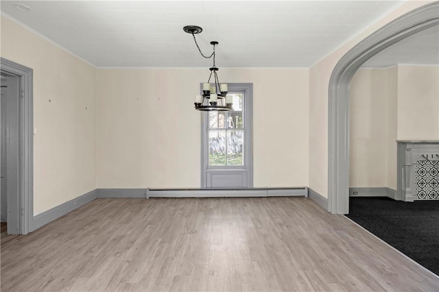 unfurnished dining area with light wood-type flooring, an inviting chandelier, baseboard heating, and crown molding