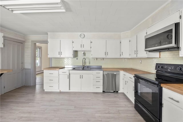 kitchen featuring crown molding, white cabinets, light hardwood / wood-style floors, and appliances with stainless steel finishes