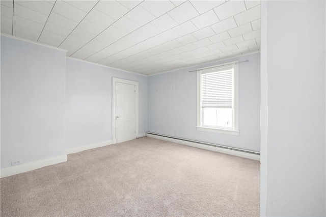 empty room with carpet flooring, ornamental molding, and a baseboard heating unit