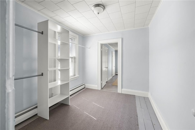 walk in closet featuring baseboard heating and wood-type flooring