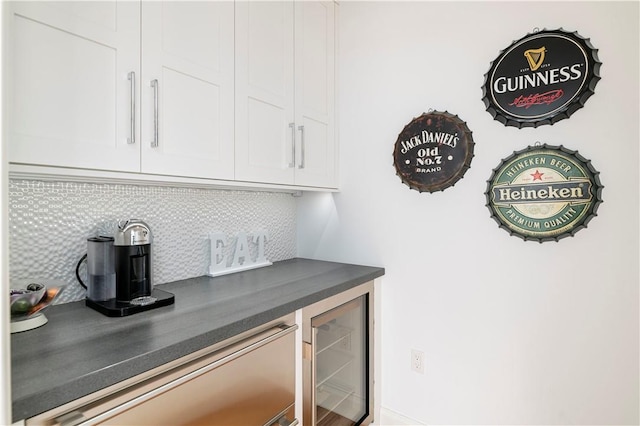 bar featuring backsplash, white cabinetry, and beverage cooler