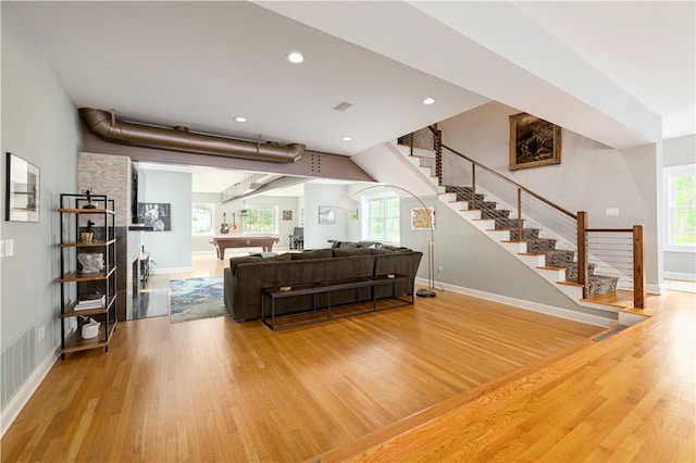 living room featuring wood-type flooring, plenty of natural light, and pool table