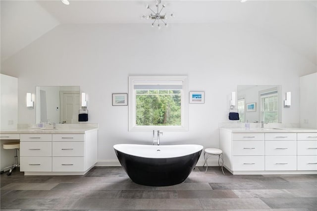 bathroom with vanity, a tub to relax in, and high vaulted ceiling