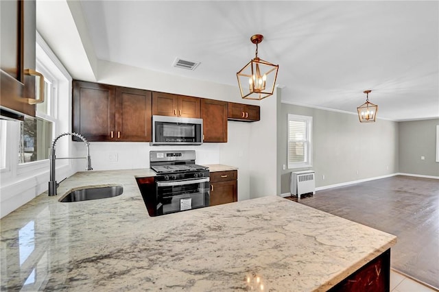 kitchen featuring plenty of natural light, sink, black range with gas cooktop, and radiator