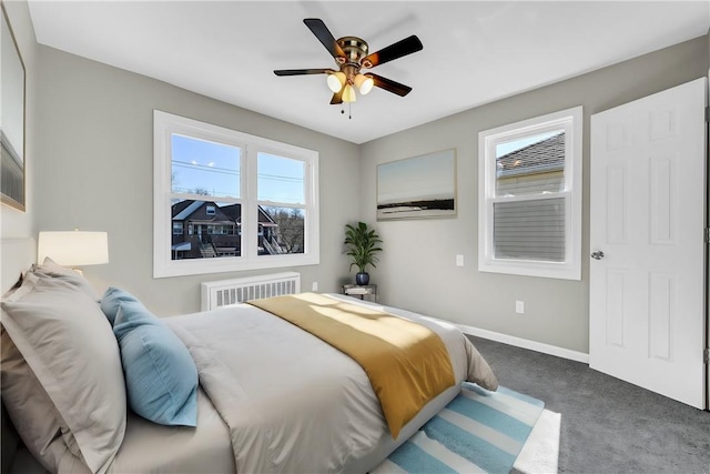 carpeted bedroom with ceiling fan and radiator