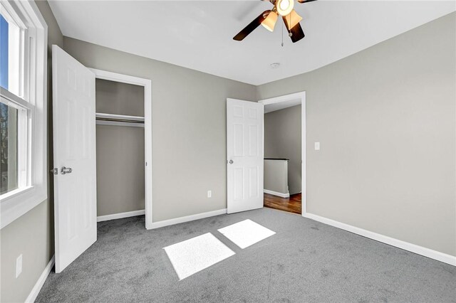 unfurnished bedroom with carpet flooring, ceiling fan, and a closet