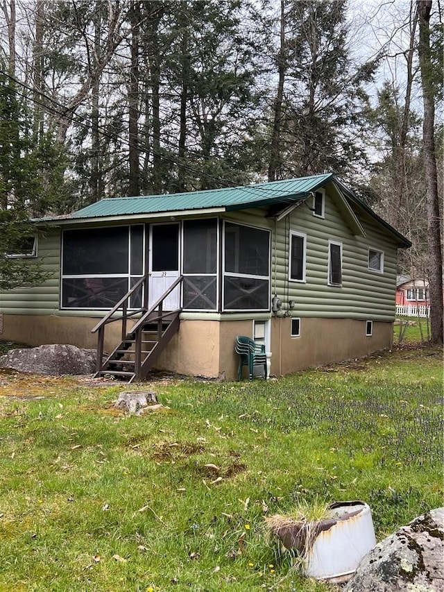 view of front of house featuring a sunroom and a front lawn