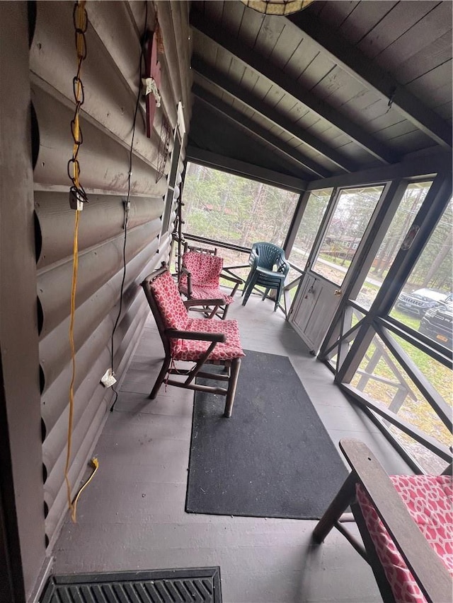 unfurnished sunroom featuring vaulted ceiling with beams and wood ceiling