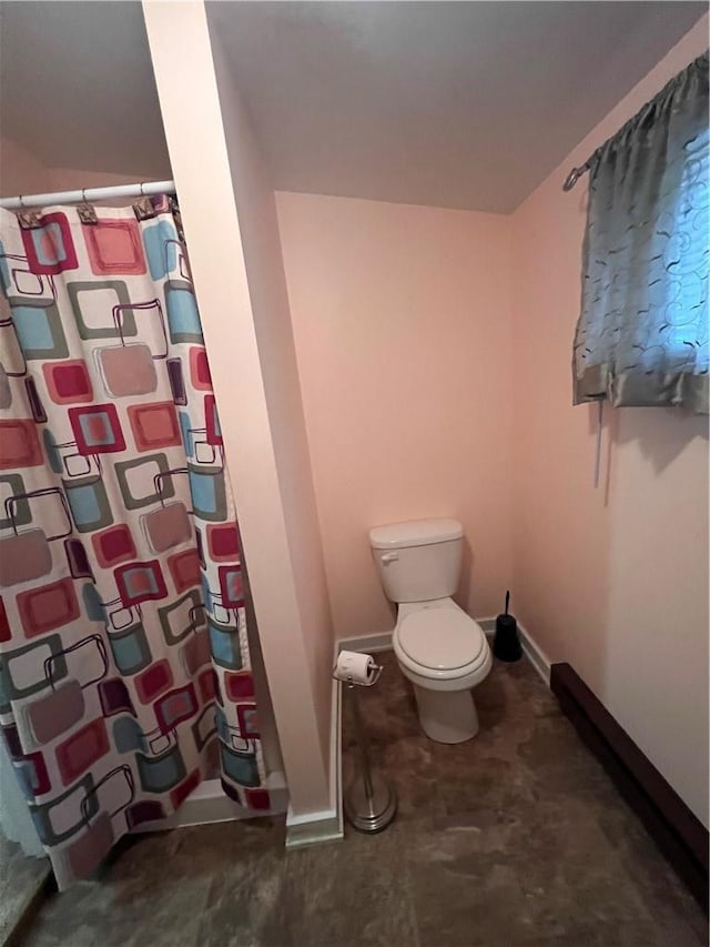 bathroom featuring a shower with shower curtain and toilet