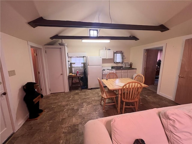 dining space featuring lofted ceiling with beams