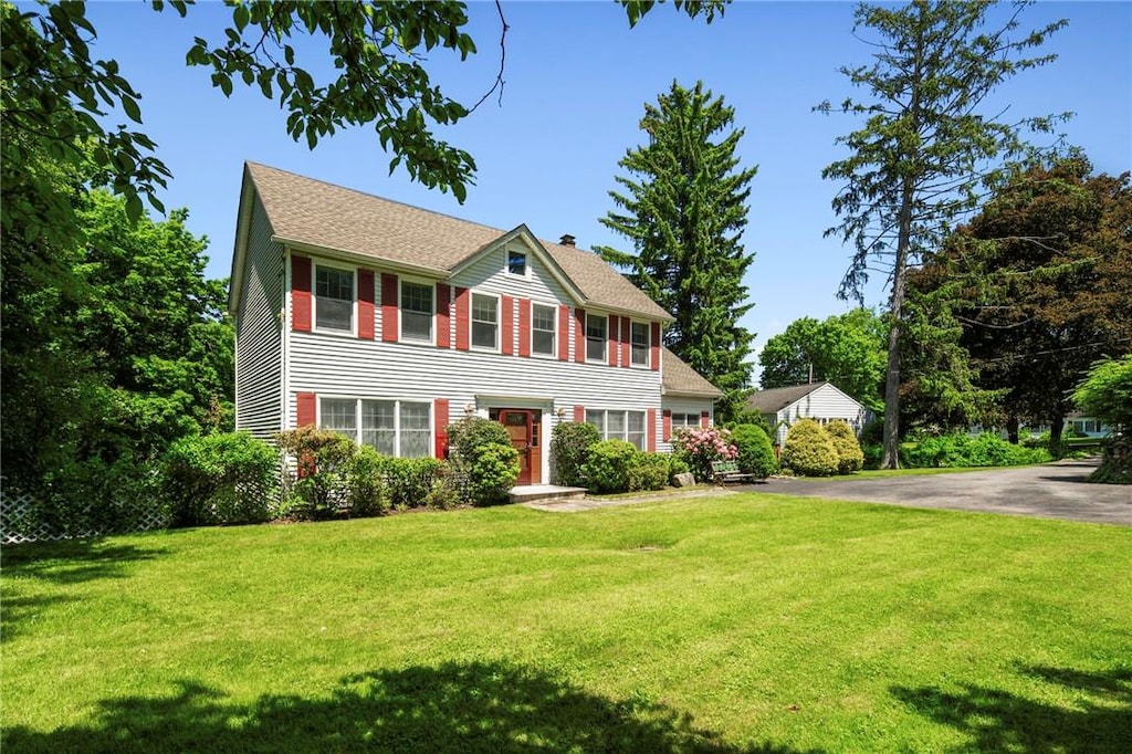 colonial home featuring a front yard