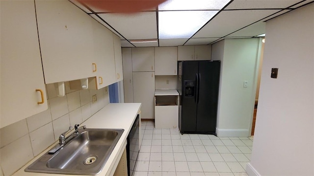 kitchen with a paneled ceiling, decorative backsplash, sink, and black appliances