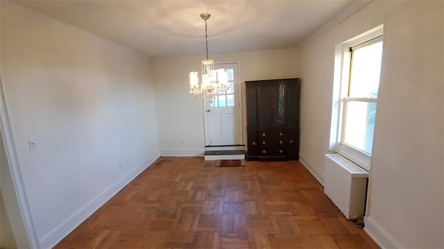 unfurnished dining area featuring plenty of natural light, dark parquet flooring, radiator heating unit, and an inviting chandelier