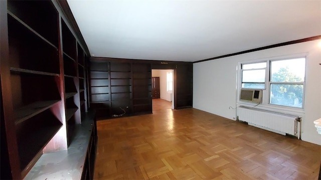 unfurnished room featuring parquet floors, crown molding, and radiator