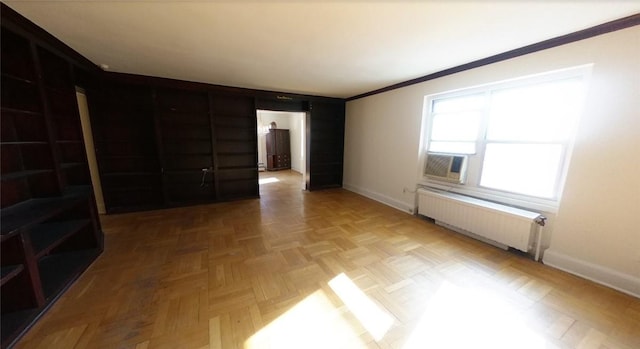 spare room with cooling unit, radiator, light parquet flooring, and ornamental molding