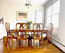 dining room with hardwood / wood-style flooring and baseboard heating