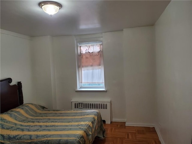 bedroom with radiator heating unit and parquet flooring