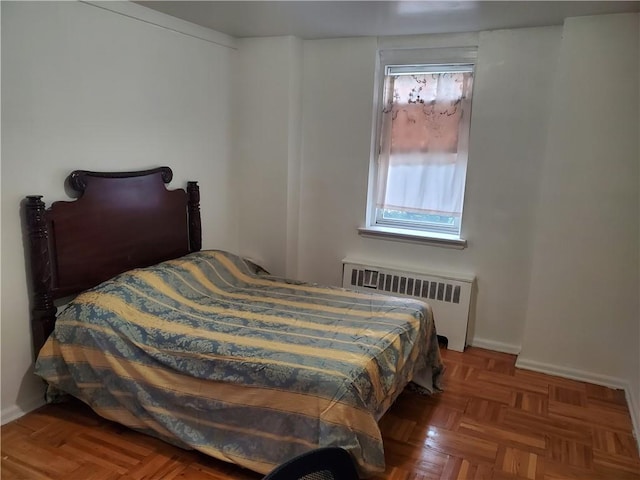 bedroom with radiator and dark parquet flooring