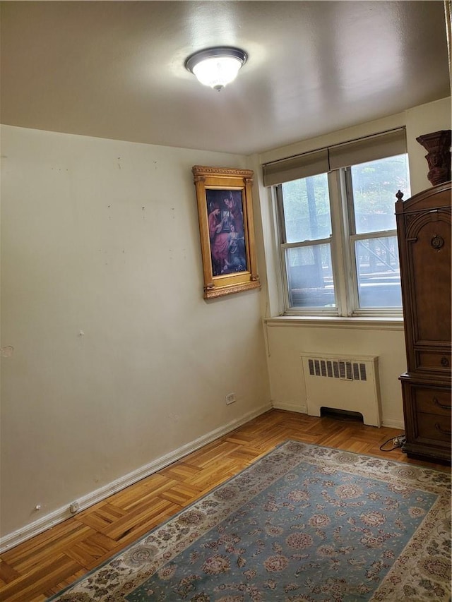 interior space featuring radiator heating unit and light parquet floors