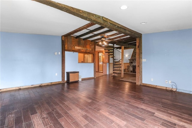 unfurnished living room with vaulted ceiling with beams and hardwood / wood-style floors