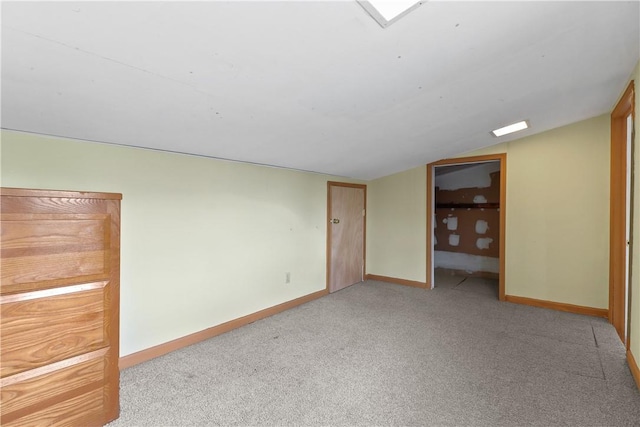 empty room featuring light colored carpet and lofted ceiling