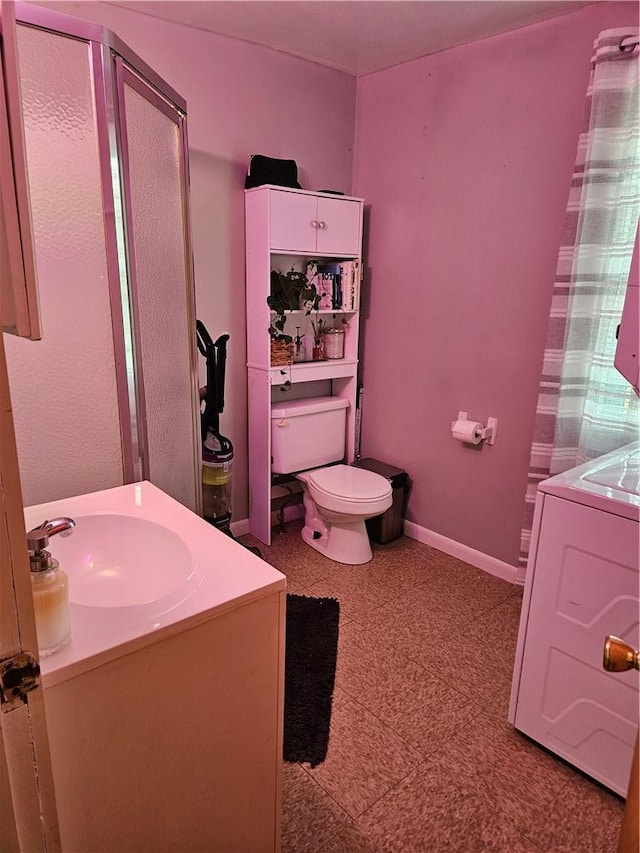 bathroom with washer / clothes dryer, a shower, vanity, and toilet