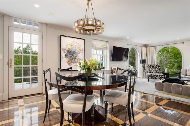 dining space with plenty of natural light, a notable chandelier, and ornamental molding