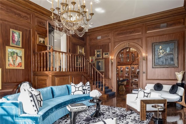 sitting room with a chandelier, hardwood / wood-style flooring, crown molding, and wooden walls