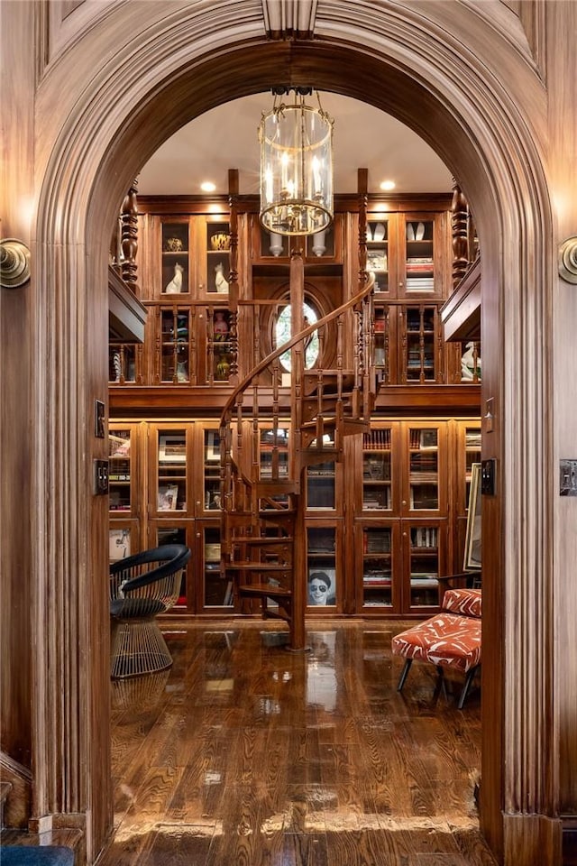 wine area featuring dark wood-type flooring, lofted ceiling, and an inviting chandelier