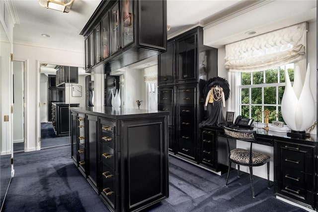 bar featuring ornamental molding and dark colored carpet