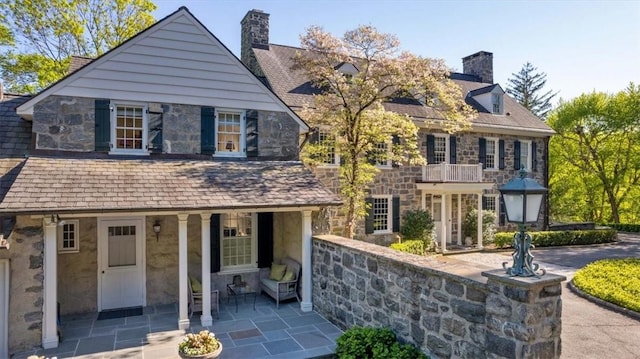 view of front of property with a patio area and a balcony