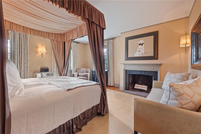 bedroom featuring a fireplace and light carpet