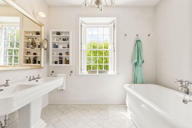 bathroom with tile patterned flooring, double sink, a tub to relax in, and ornamental molding