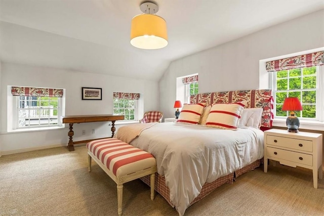 carpeted bedroom with vaulted ceiling and multiple windows