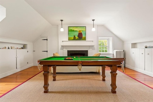 game room with hardwood / wood-style flooring, lofted ceiling, radiator, and pool table