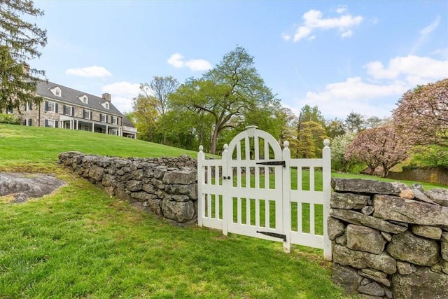 view of gate with a yard