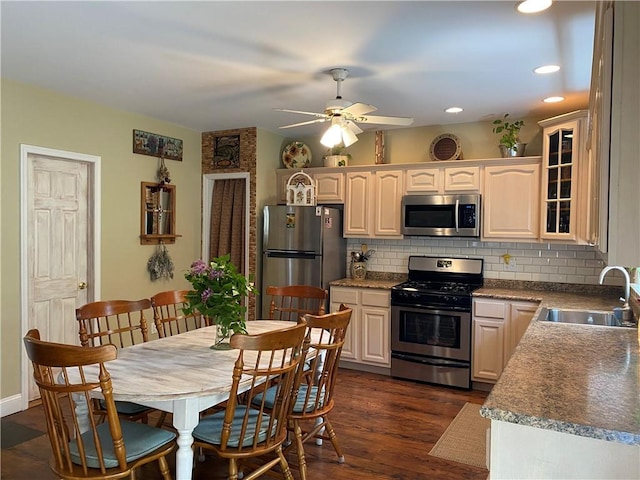 kitchen with sink, ceiling fan, decorative backsplash, dark hardwood / wood-style flooring, and stainless steel appliances