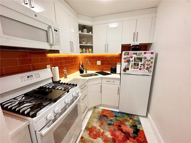 kitchen featuring backsplash, white appliances, sink, light tile patterned floors, and white cabinetry