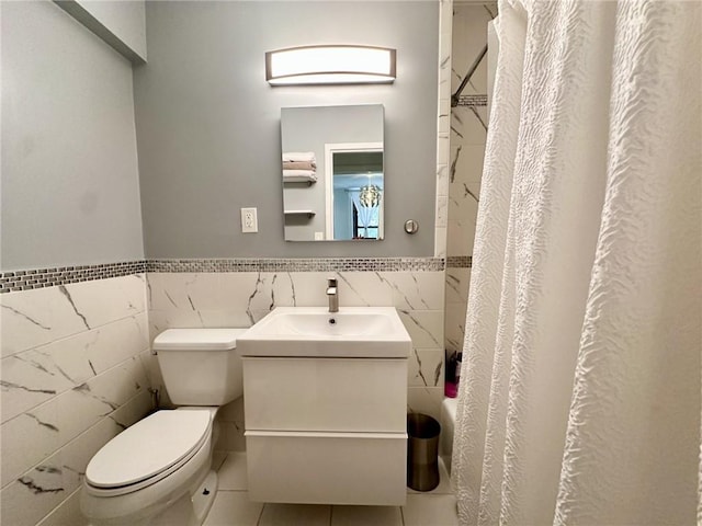 bathroom with tile patterned floors, curtained shower, toilet, and tile walls