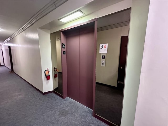 hall featuring dark colored carpet and elevator