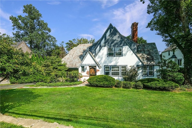 english style home featuring a front yard