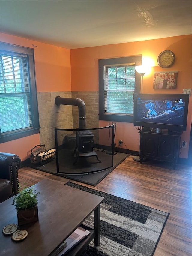 exercise room with wood-type flooring and a wood stove