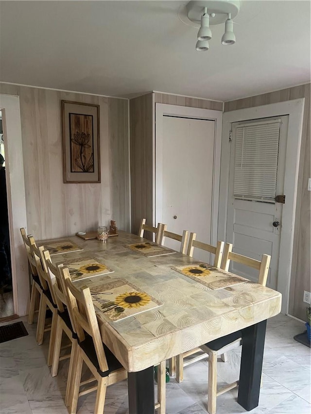 dining space featuring wood walls