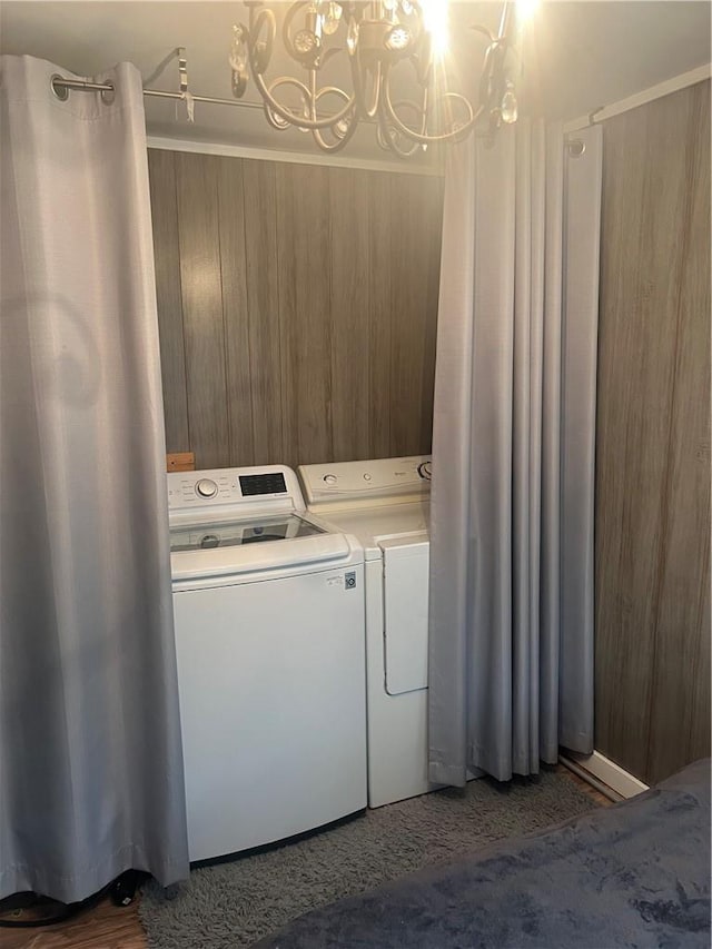 clothes washing area with separate washer and dryer and an inviting chandelier