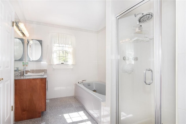 bathroom featuring vanity, independent shower and bath, and tile walls