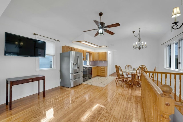 kitchen featuring appliances with stainless steel finishes, ceiling fan with notable chandelier, light hardwood / wood-style flooring, and plenty of natural light