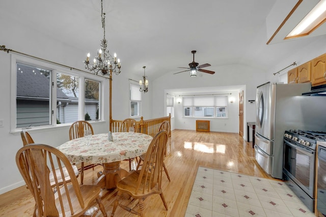 dining area featuring ceiling fan with notable chandelier, light hardwood / wood-style flooring, and vaulted ceiling